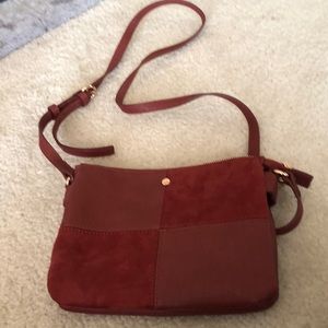 Lauren Conrad red suede and patent top-zippered purse. Adjustable strap length.